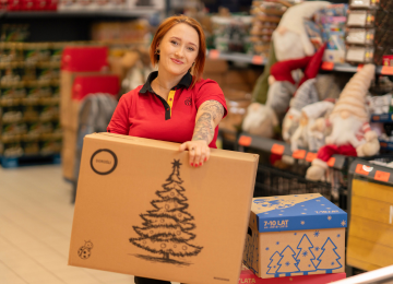 Pracowniczka sklepu trzymająca karton z paczką swiąteczną.