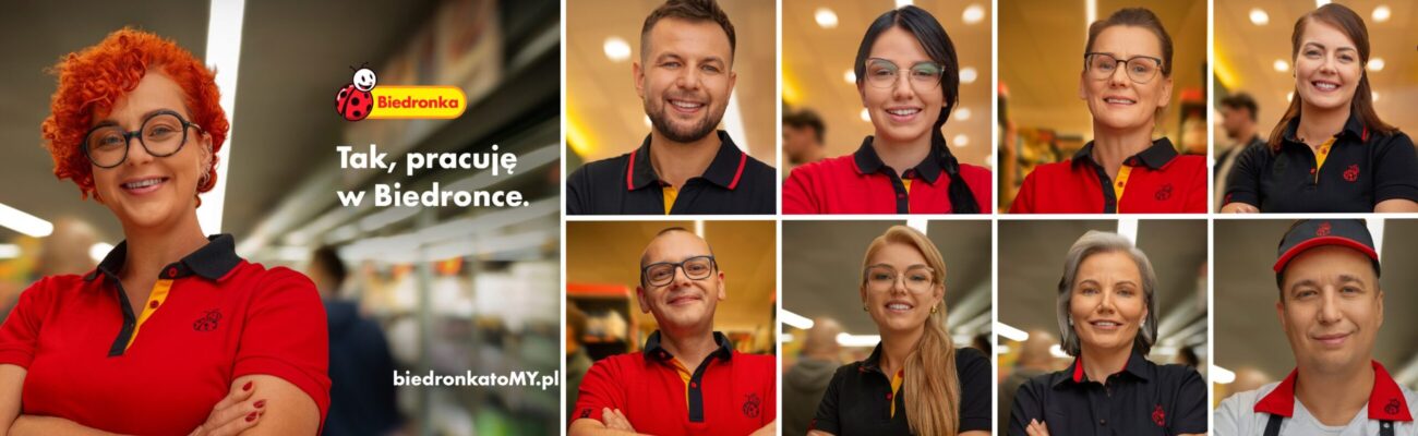 Uśmiechnięci pracownicy Biedronki na tle sklepu Biedronka.