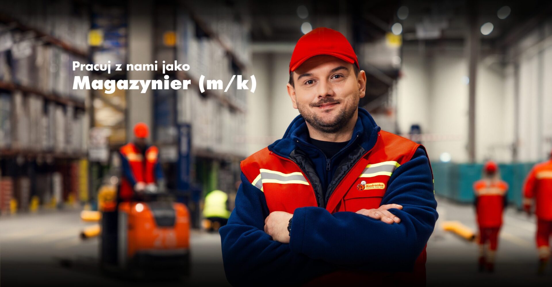 Pracownik centrum dystrybucyjnego biedronki na tle magazynu.