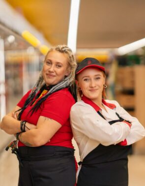 Kobiety w strojach służbowych na tle sklepu Biedronka.